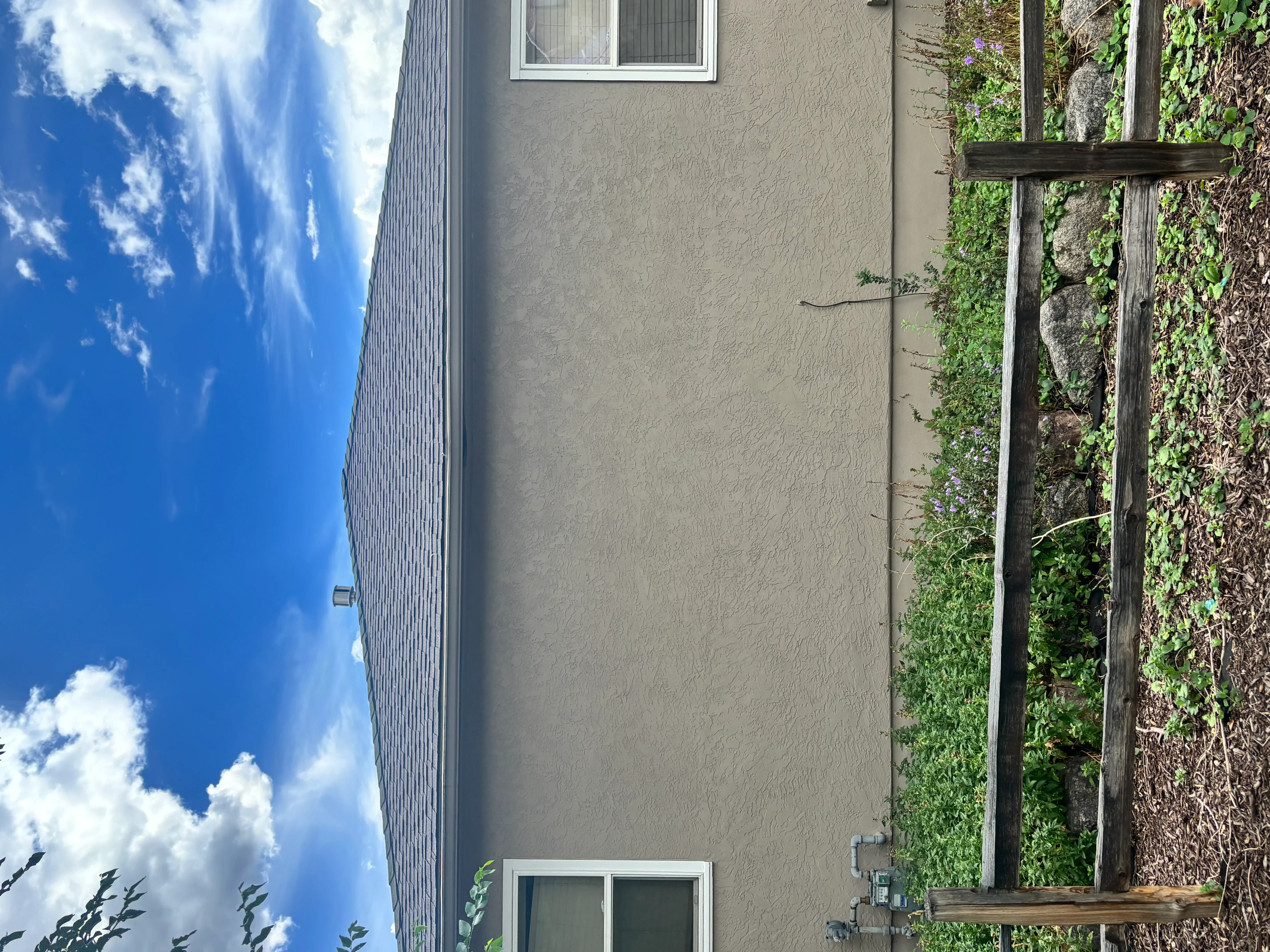Corrugated metal roof with vertical ribbing on residential stucco exterior wall