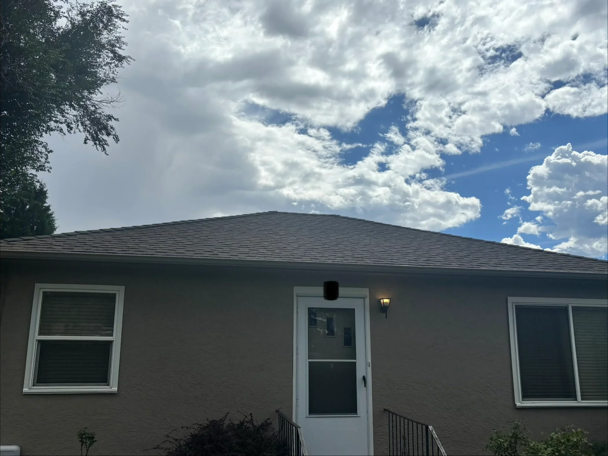 New gray architectural asphalt shingle roof on single-story brick home with white trim